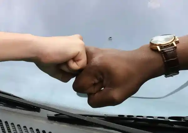 A photo of a blank and a white hand fist bumping